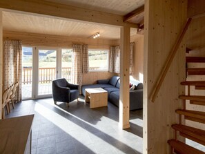 A wooden interior with a sofa, armchair, and a small table. - One-bedroom Cabin (Sankt Georgen am Kreischberg)