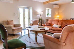 A cozy living room with a round wooden coffee table, a sofa, and a chair.