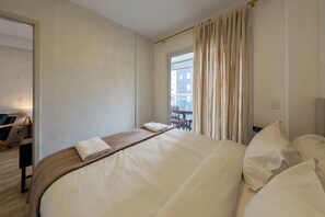 A hotel room with a bed, a window with curtains, a chair, and a table. - Almeida by Bhomy  (São Paulo)