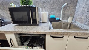 Una cocina con microondas, fregadero y lavavajillas.