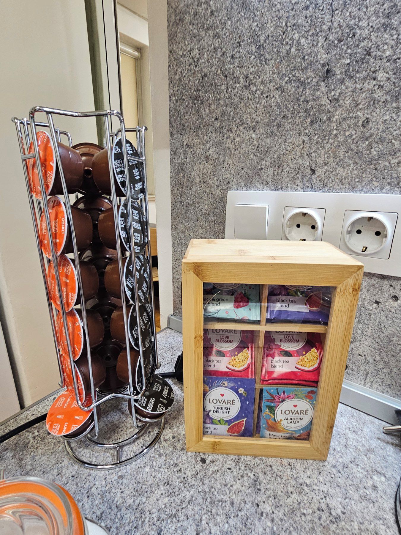 A kitchen counter with a coffee machine and a display of tea blends.