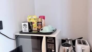 A microwave with a tray of food items and a toaster on a countertop.