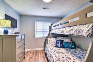 A bedroom with bunk beds, a dresser, a lamp, and a window with blinds. - Your Beach Escape – Close to Cherry Grove Beach (Little River)