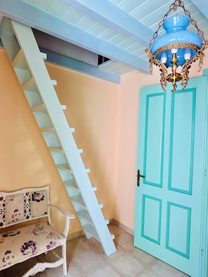 Eine Treppe mit weißer Handlauf, die zu einer Tür mit blauem Rahmen führt.