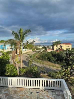 A residential area with a paved road, palm trees, and houses with red roofs. - Peaceful, private 2-bedroom house with exclusive pool in Montego Bay (Montego Bay)