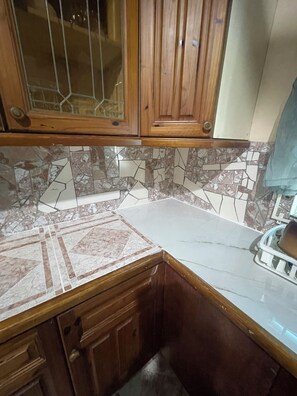 A kitchen with wooden cabinets, a marble countertop, and a tiled backsplash. - Peaceful, private 2-bedroom house with exclusive pool in Montego Bay (Montego Bay)