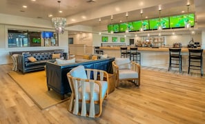 A spacious living area with a bar, sofas, and chairs. - Coastal Fun at Bayside Resort | Near the Beach (Selbyville)