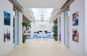 A hallway leading to a reception area with a sign reading 'Welcome to the Health Aquatic Club.' - Coastal Fun at Bayside Resort | Near the Beach (Selbyville)