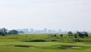 A golf course with bunkers and a distant city skyline. - Coastal Fun at Bayside Resort | Near the Beach (Selbyville)