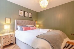 A bedroom with a bed, bedside tables, and wall-mounted lamps. - Cosy stylish 1 bed flat in Fulham w patio (London)