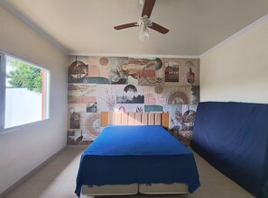 A bedroom with a bed, a ceiling fan, a window, and a wall with a collage of images. - BEAUTIFUL HOUSE IN GATED COMMUNITY (Itupeva)