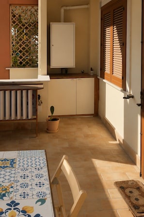 Eine kleine Küche mit einem weißen Schrank, einem Blumentopf und einer Heizung.