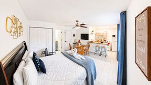 Ein Hotelzimmer mit Bett, Schreibtisch, Stuhl, einer Küchenzeile und einem Badezimmer.