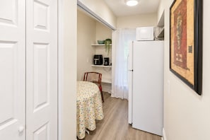 A compact kitchen with a refrigerator, a microwave, and a coffee maker on the counter. - Two Private Jacksonville Studios Near Hospitals (Jacksonville)