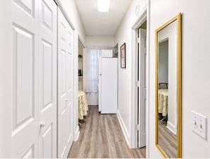 Hallway with wood-look flooring leading to the kitchen and dining area. - Bright Jacksonville Studio Near Hospitals (Jacksonville)