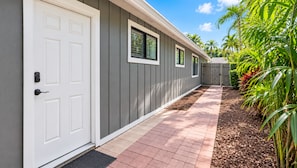 A residential building with a grey exterior, white doors, and a paved walkway. - Bright Jacksonville Studio Near Hospitals (Jacksonville)