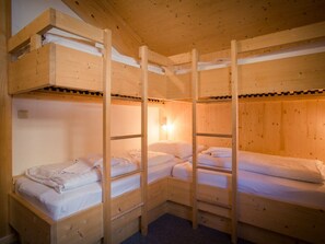 A wooden bunk bed room with a ladder, a wall-mounted light, and a small window. - Cabin in Turrach With Sauna and Terrace (Stadl-Predlitz)