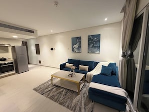 A modern living room with a sofa, coffee table, and artwork on the wall. - Steps from Al-Sayah Square & RCSI FES132O (Busaiteen, Muharraq Governorate, Bahrain)