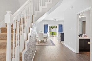 Un interior espacioso con una escalera, un comedor y una cocina.