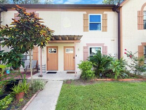 A two-story house with a front porch, a mailbox, and a well-maintained lawn. - Clearwater Comfort 2BR Townhome Near HCA (Clearwater)