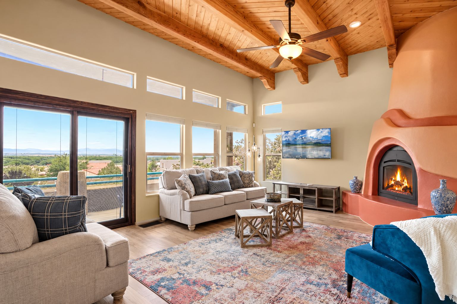 A spacious living room with a fireplace, a sofa, a coffee table, and a view of the outdoors.