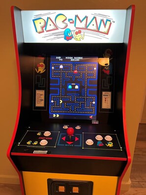 A Pac-Man arcade game with a score display, joystick, and coin-operated buttons. - Sweeping Views, Arcade, Putting, Chef's Kitchen (Albuquerque)