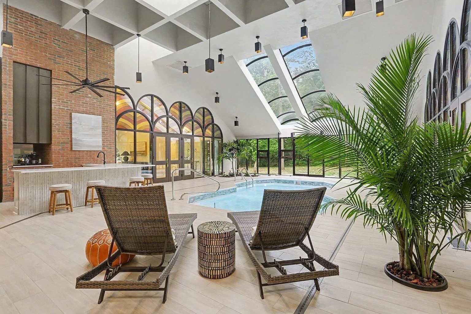 Zona junto a la piscina con sillones, bar y vistas a la piscina.