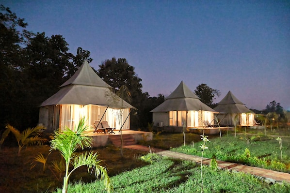 A row of dome-shaped tents with seating arrangements and a pathway leading to them.