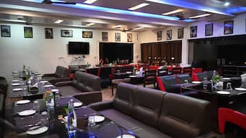 A restaurant with multiple dining areas, including booths and tables, with ceiling fans and recessed lighting.