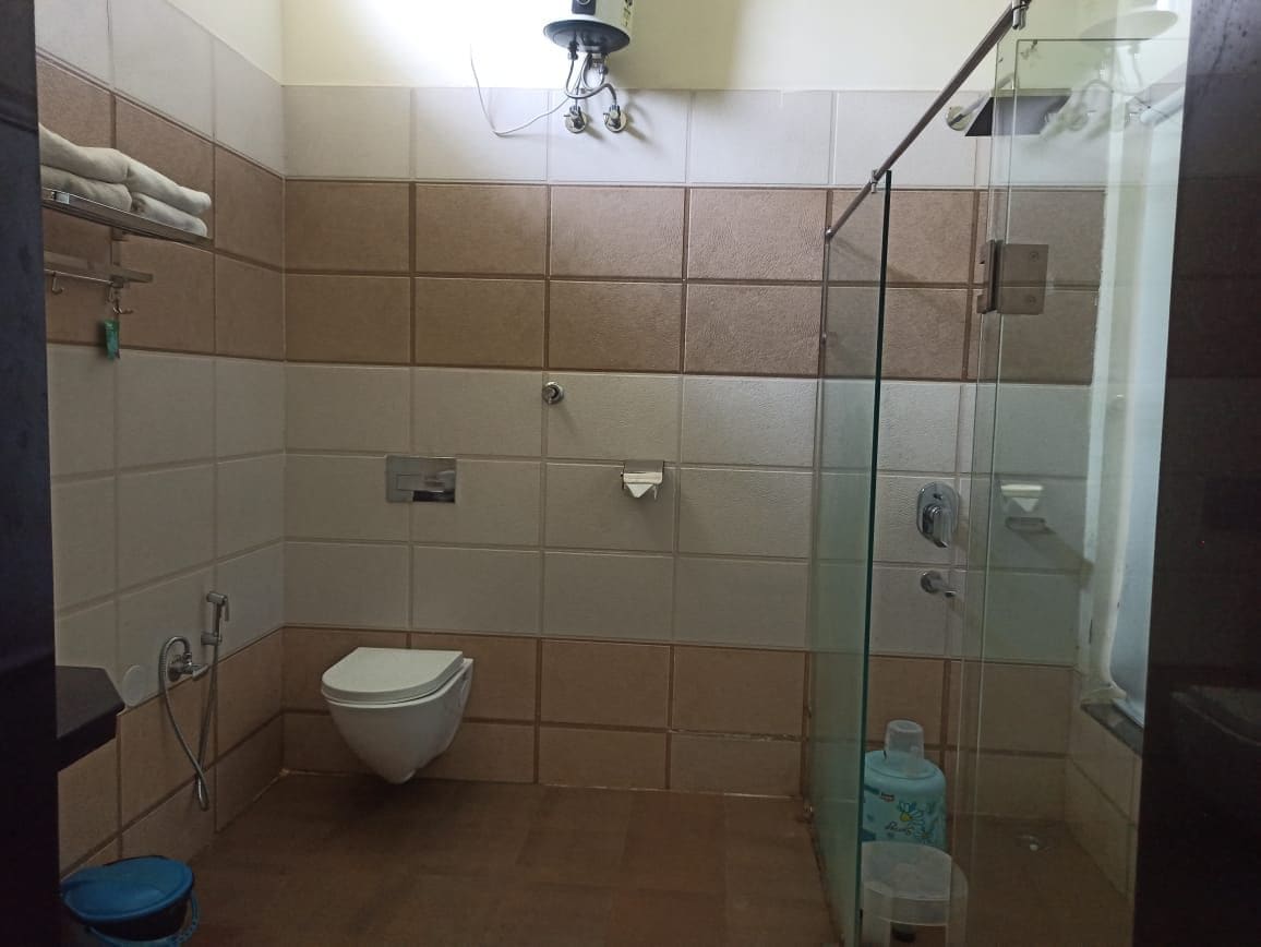 Ein Badezimmer mit Duschkabine aus Glas, Toilette und Waschbecken.