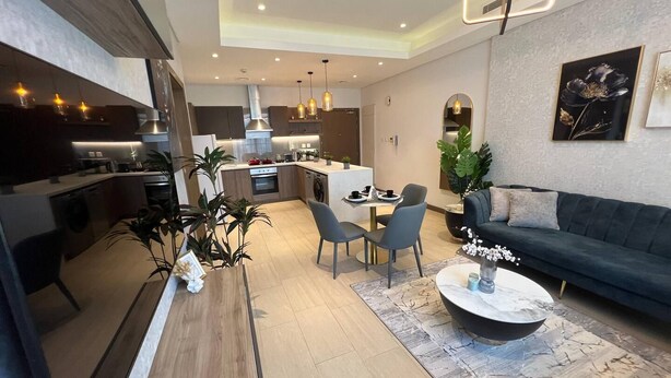 A modern living room with a sofa, coffee table, and dining area. - Stylish Downtown & Close to Attractions F97O (Manama)