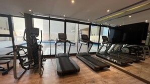A gym with treadmills, a stationary bike, and a rowing machine. - Stylish Downtown & Close to Attractions F97O (Manama)