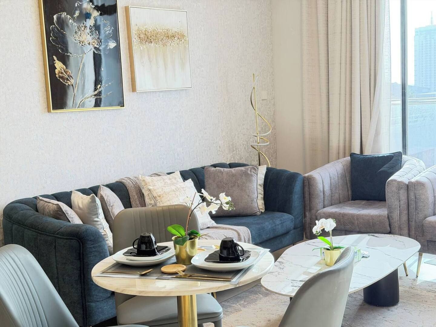 A modern living room with a sofa set, a coffee table, and a dining table set for two.