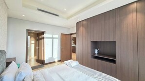 A modern hotel room with a large bed, built-in wardrobe, and a television. - Stylish Downtown & Close to Attractions F97O (Manama)