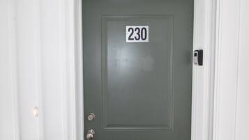 A door with the number 230, a doorbell, and a mail slot.