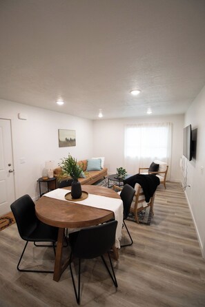 A modern living room with a dining table, chairs, a sofa, and a TV. - 3BR Chubbuck Stay | Near Mall & Dining (Pocatello)