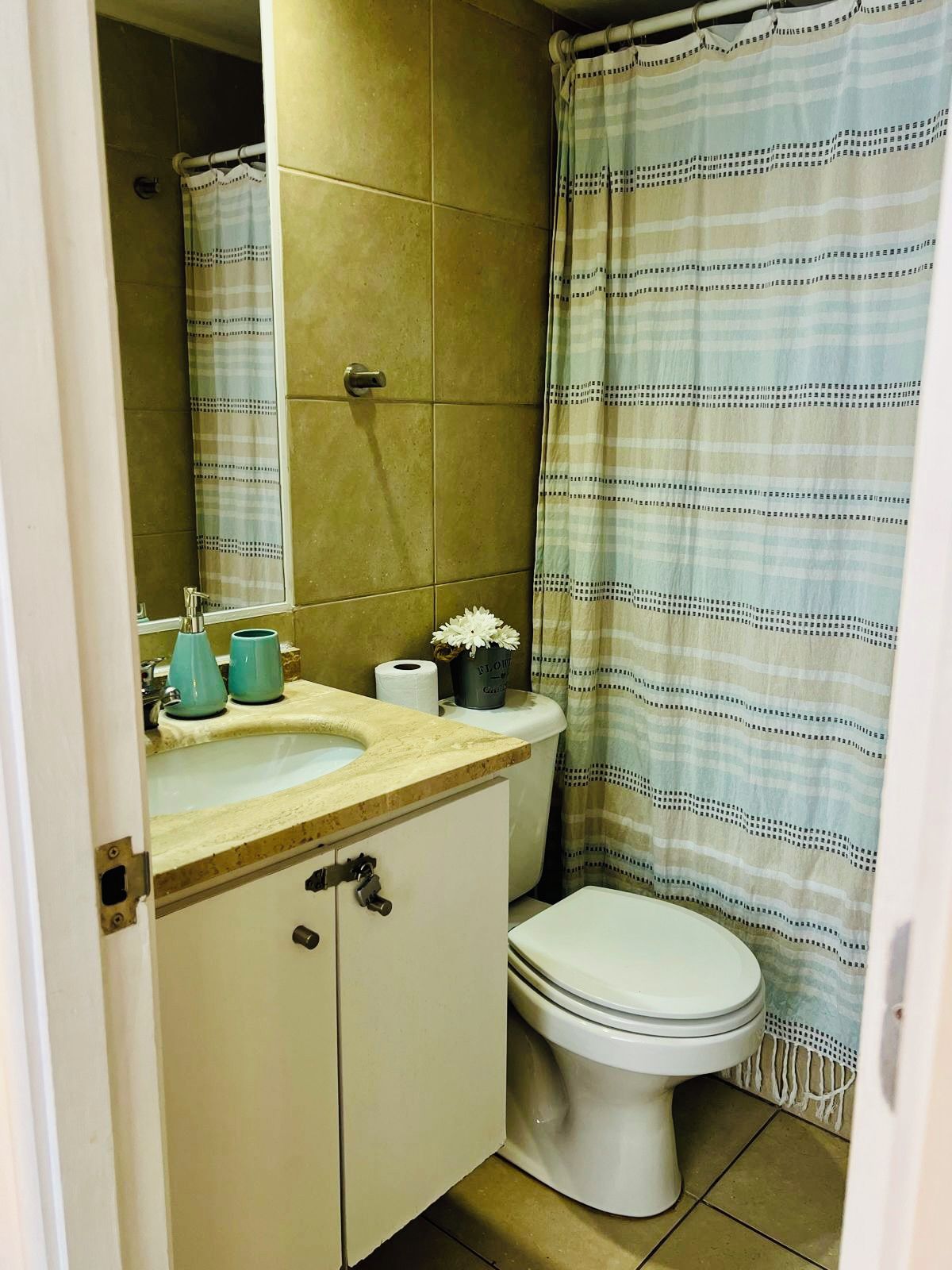 Een badkamer met toilet, wastafel en spiegel.