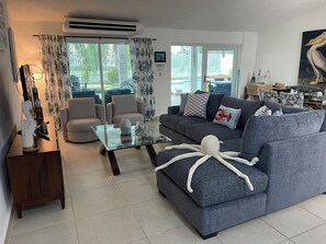 A modern living room with a grey sofa, a glass coffee table, and a decorative octopus. - Charming Beach Home Dorado Del Mar and Golf (Dorado)