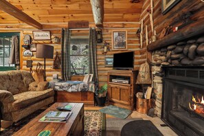 A cozy log cabin interior with a fireplace, a television, and a comfortable seating area. - 3-bedroom log cabin in tranquil Sturgeon Bay close to Lake Michigan (Sturgeon Bay)