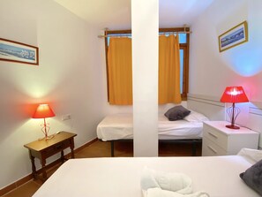 A bedroom with a single bed, a bedside table, a nightstand, a lamp, and a window with curtains. - Apartment in Nerja Near Balcon de Europa (Nerja)