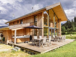 A wooden cabin with a deck, outdoor seating, and a hot tub. - One-bedroom Cabin (Sankt Georgen am Kreischberg)
