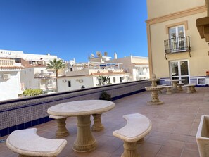 A rooftop terrace with outdoor furniture, a decorative fountain, and a view of the cityscape. - Apartment in Nerja Near Balcon de Europa (Nerja)