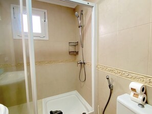 A bathroom with a shower, toilet, and a small window. - Apartment in Nerja Near Balcon de Europa (Nerja)