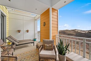 Covered outdoor balcony with wicker seating and scenic sand dune views. - New! 3Bd 3Bth Oceanfront / Pool / Gym / Beach (Virginia Beach)