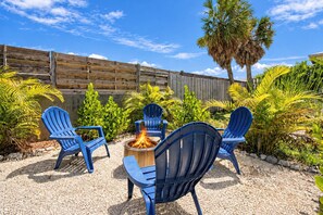 Private tropical fire pit patio with Adirondack chairs and palm views - Full Duplex, Steps to the Beach, King Bed Masters (Holmes Beach)