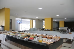 A buffet setup with various food items and a coffee station. - Themas Paradise (Rio Quente)