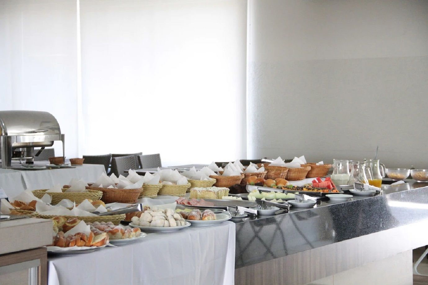Una mesa de buffet con diversos alimentos y una máquina de café.