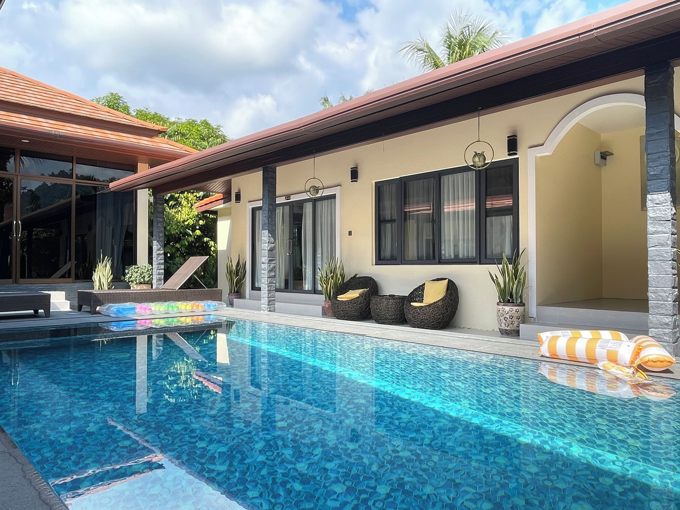 Une maison moderne dotée d’une piscine, d’un espace salon extérieur et offrant une vue sur le ciel.