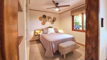 Quarto com cama, mesa de cabeceira, decoração na parede e janela com vista.
