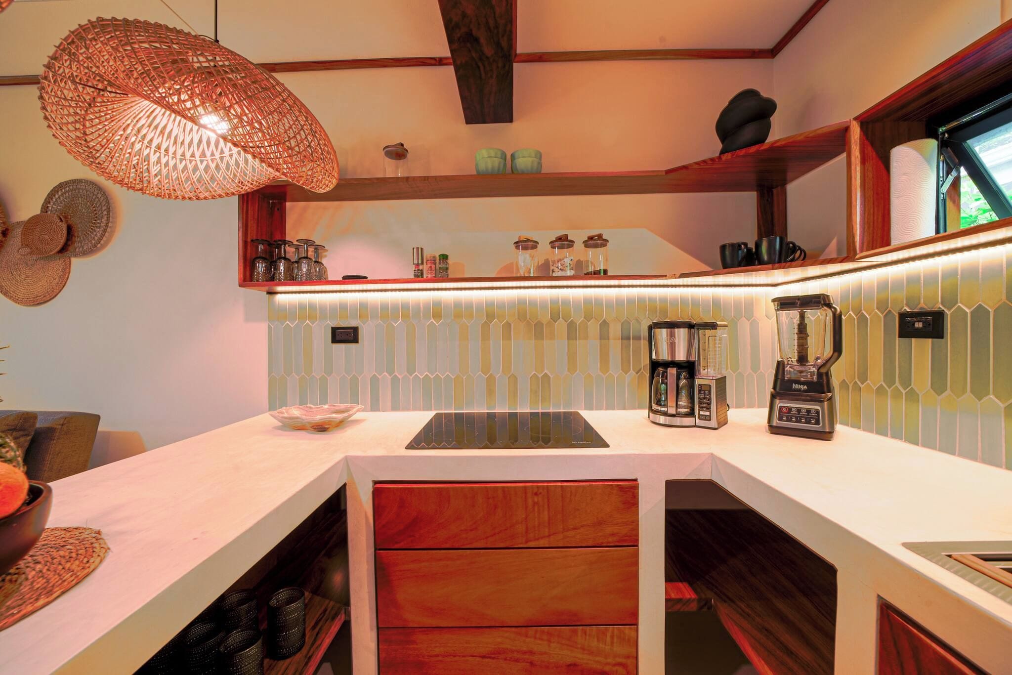 A modern kitchen with a central island, a coffee machine, and a blender.